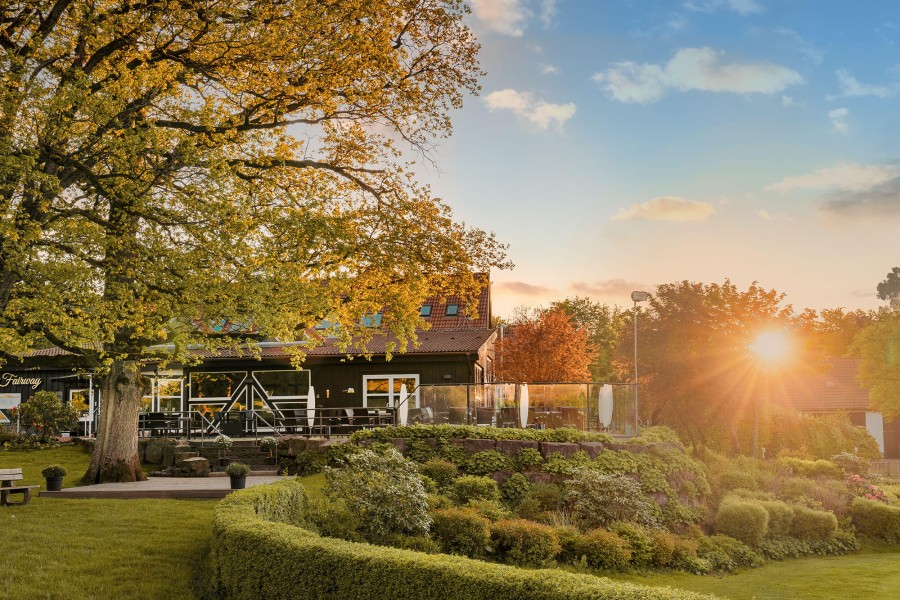 Das Clubhaus mit Innen- und Aussengastronomie, bei einem idyllischen Sonnenuntergang in Gelstern.